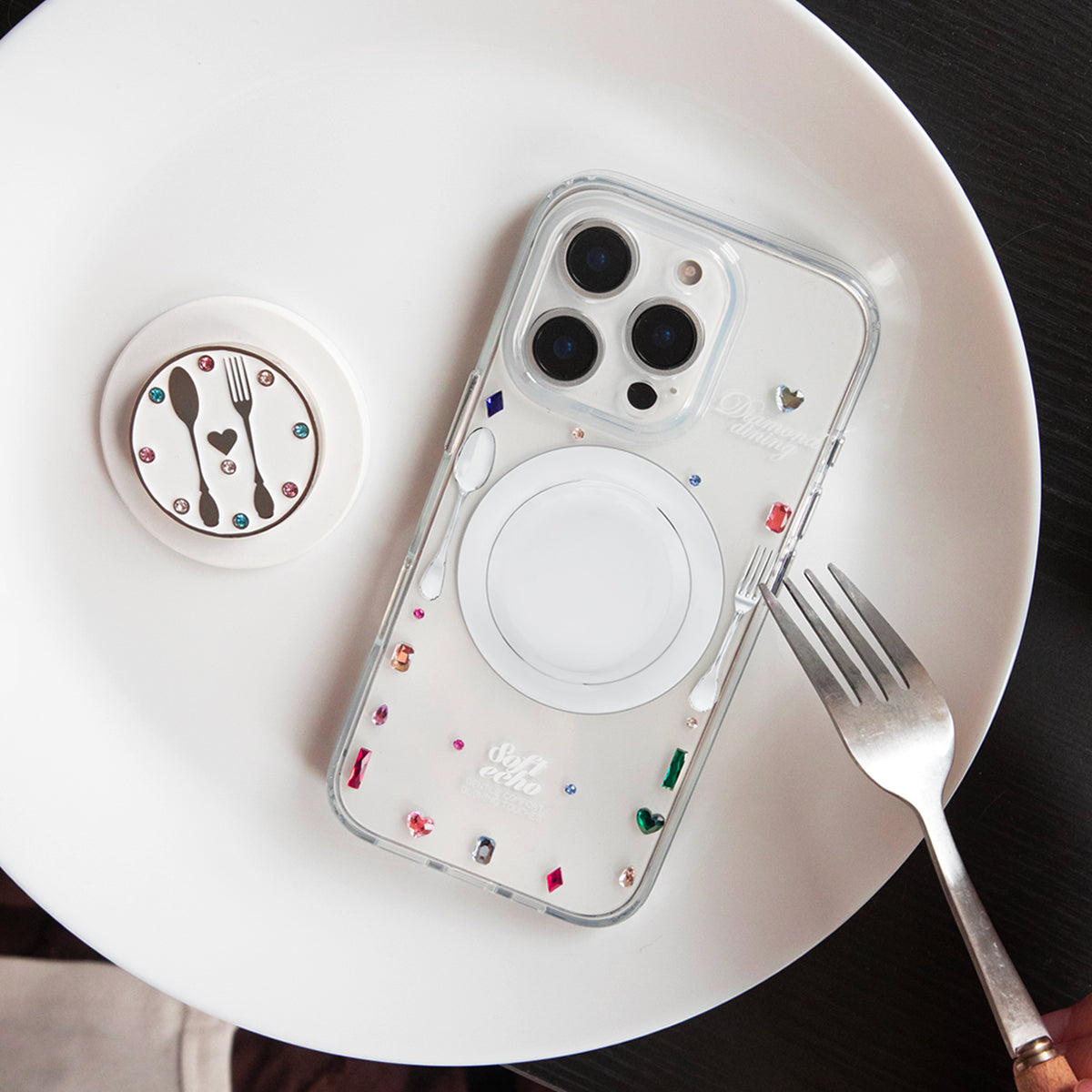 Phone case with colorful design on a white plate with a fork