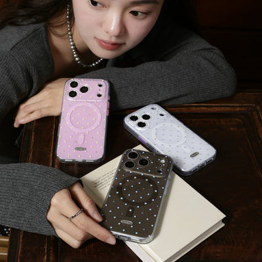 Three phone cases with different designs on a table, with a person holding one of them.