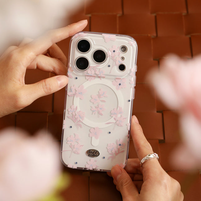 Phone case with floral design held by hands on a blurred background