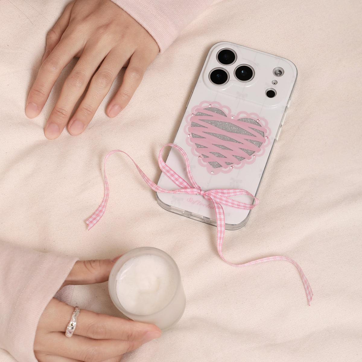Phone case with heart design and pink ribbon on a light pink background