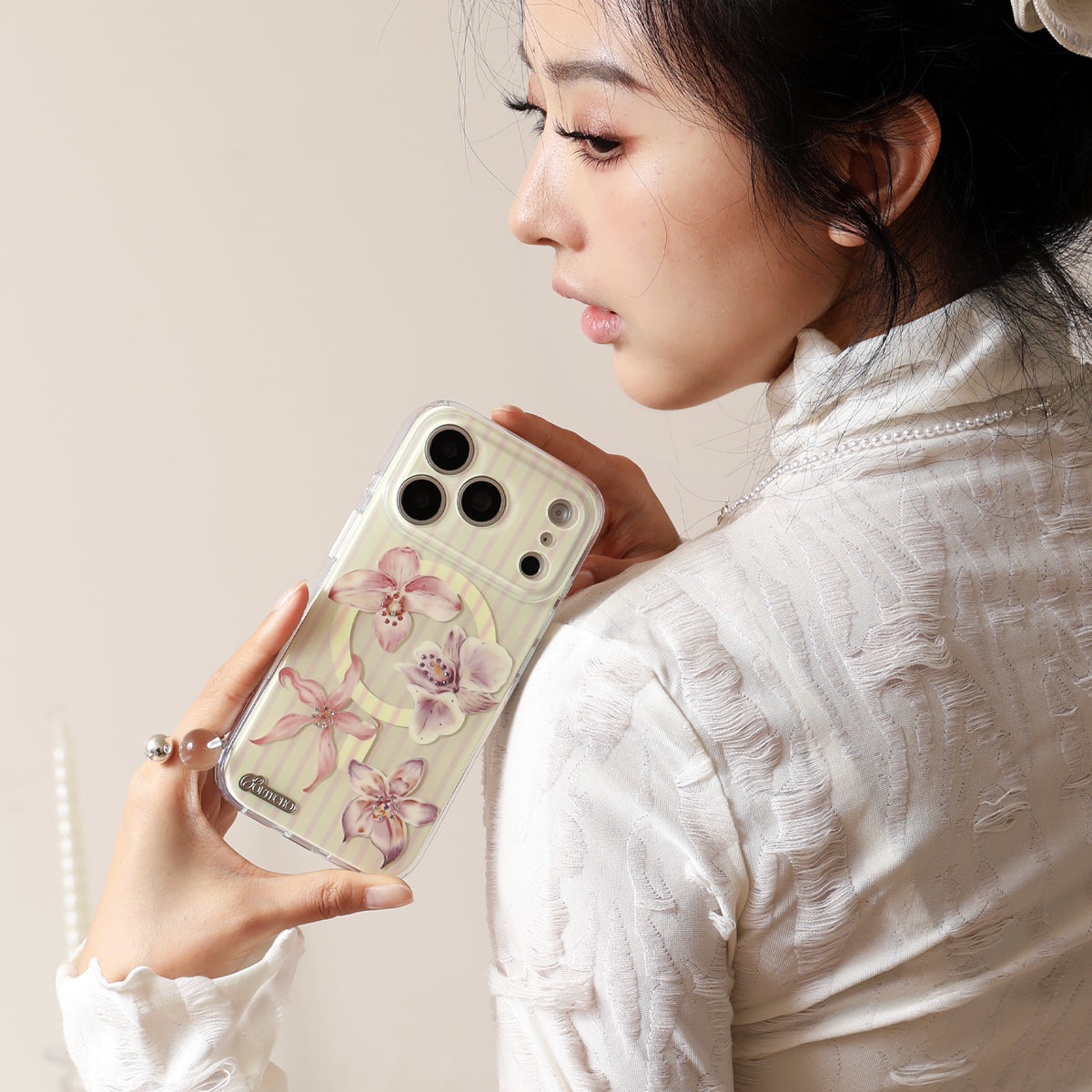Woman holding a phone with a floral case