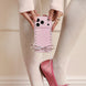 Person holding a pink phone case with decorative elements