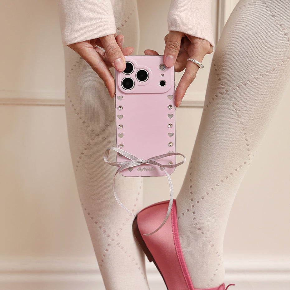 Person holding a pink phone case with decorative elements