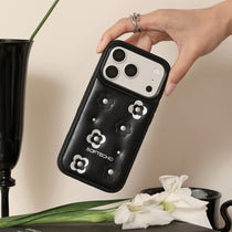 Hand holding a black phone case with floral designs and 'SOFTECHO' branding, against a neutral background.
