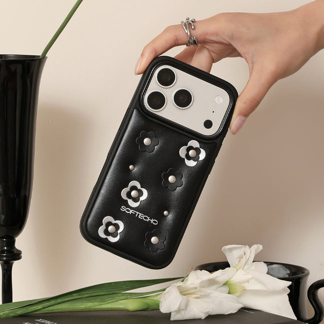 Hand holding a black phone case with floral designs and 'SOFTECHO' branding, against a neutral background.