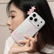 Person holding a phone with pink star design, wearing pink hair clips.
