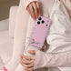 Person holding a pink phone case with heart designs and a bow.