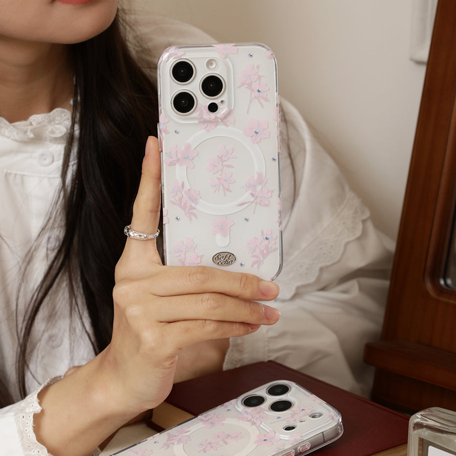 Person holding a phone with a floral case, sitting on a chair.