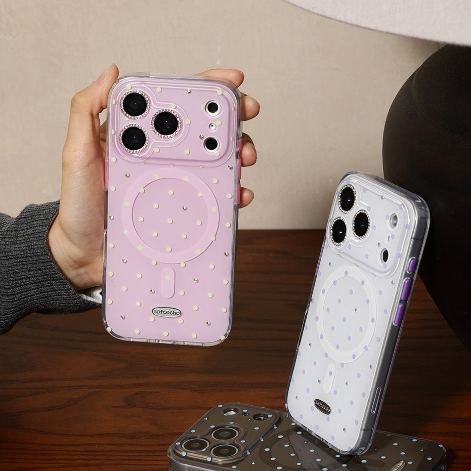 Person holding a pink phone case with a white case on a wooden surface
