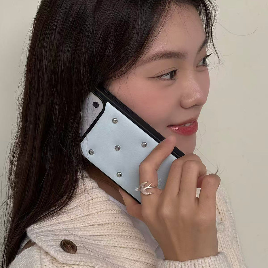Woman holding a phone to her ear with a neutral background