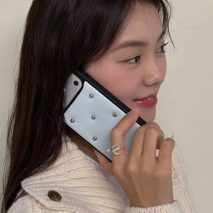 Woman holding a phone to her ear with a neutral background