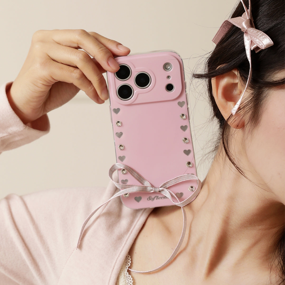 Pink phone case with heart patterns and a bow