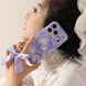 Person holding a phone with a purple bow case against a neutral background