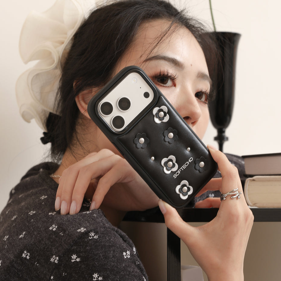 Person holding a black phone case with floral designs