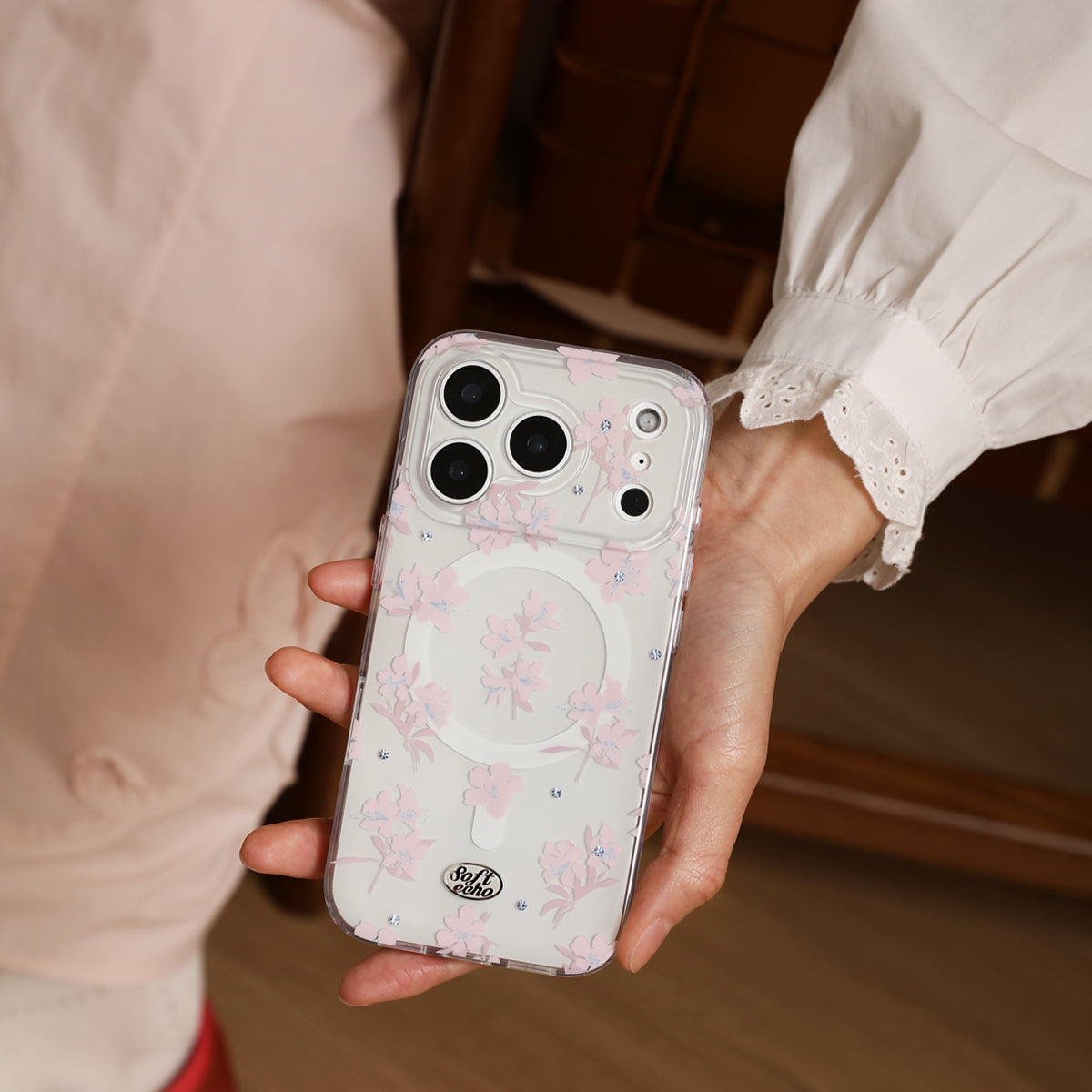Person holding a phone with a floral case in a casual setting