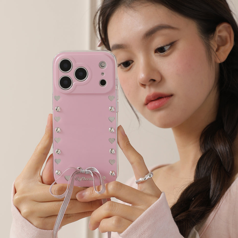 Woman holding a pink phone case with heart patterns