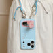 Blue phone case with strawberry design and lanyard on a white background