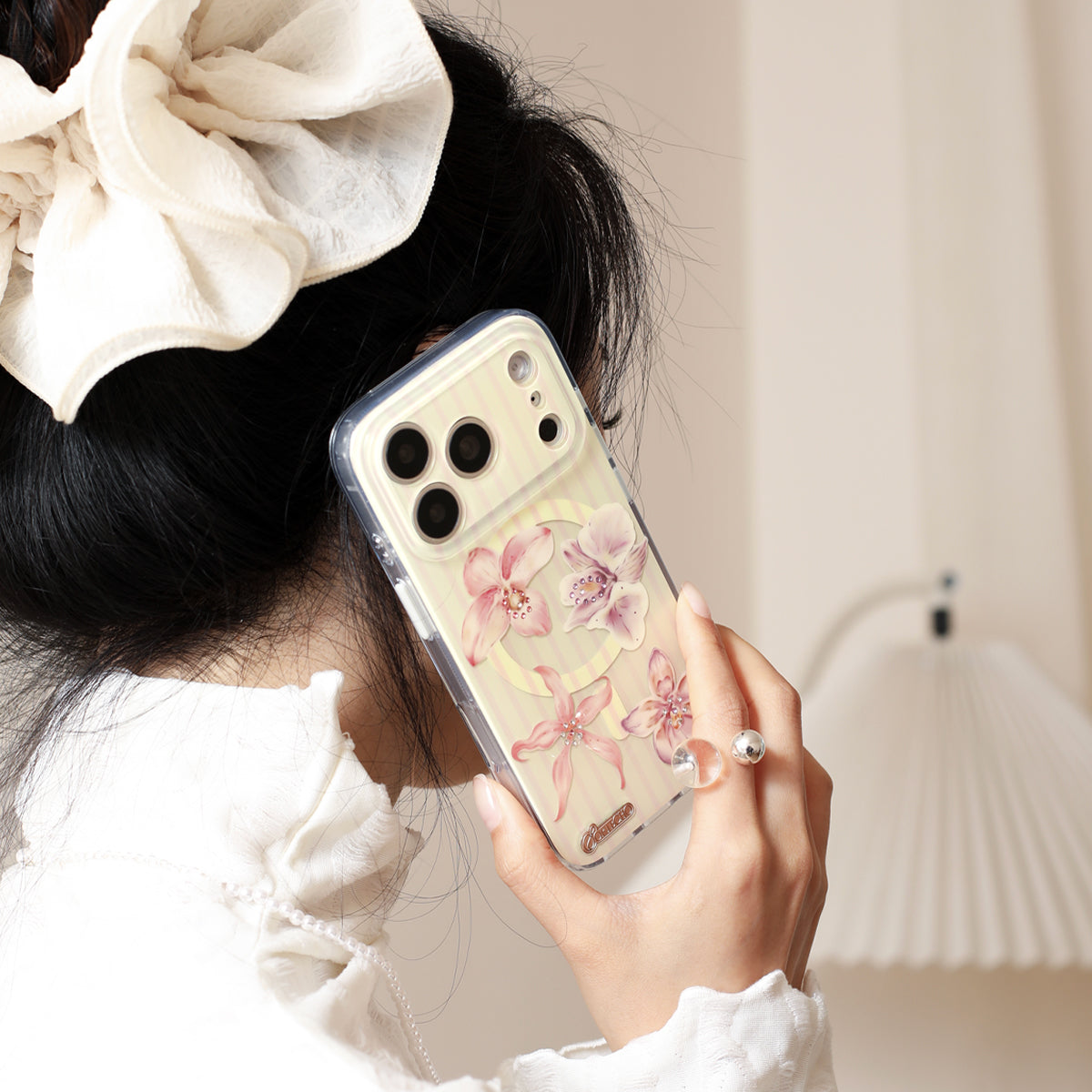 Person holding a phone with a floral case