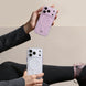 Two phone cases with circular designs held by a person against a beige background