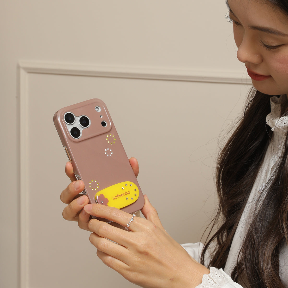 Person holding a phone with a pink case featuring a yellow character.