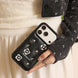 Person holding a black phone case with floral designs and 'softecho' branding.
