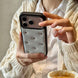 Person holding a phone with a decorative case