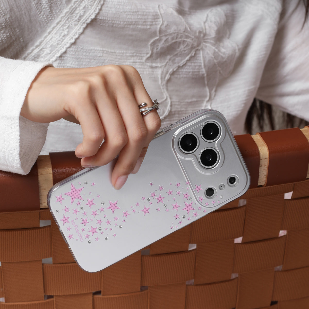 Person holding a phone with a star pattern on a woven surface