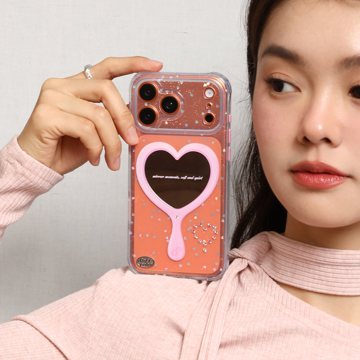 Person holding a phone case with a heart mirror 
