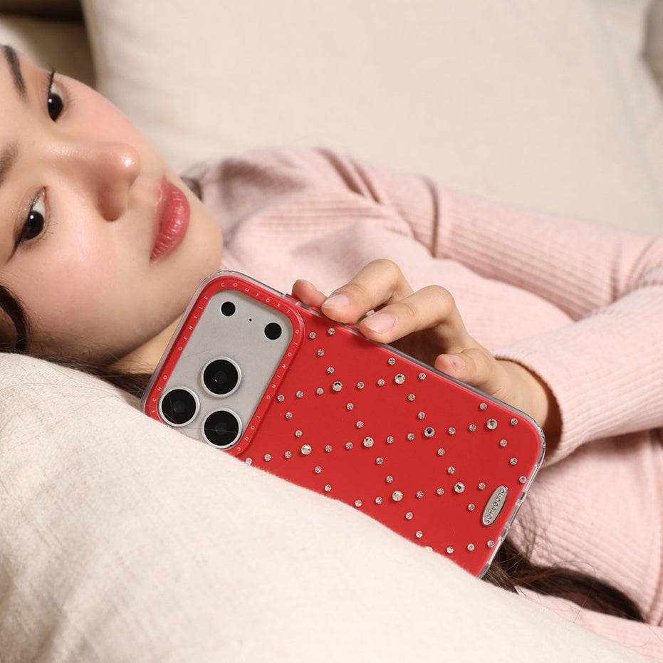 Person holding a red phone case with rhinestones