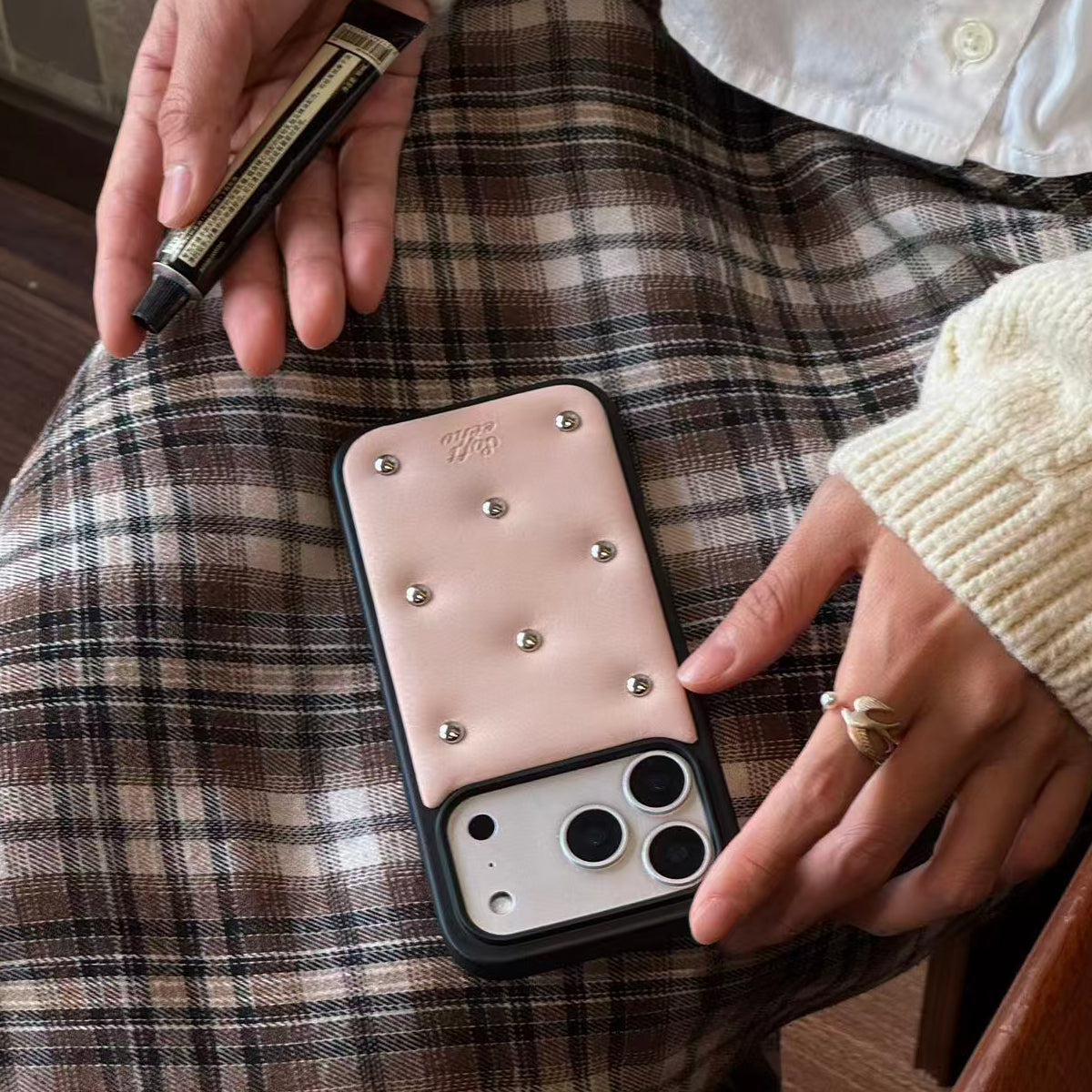 Person holding a phone with a decorative case