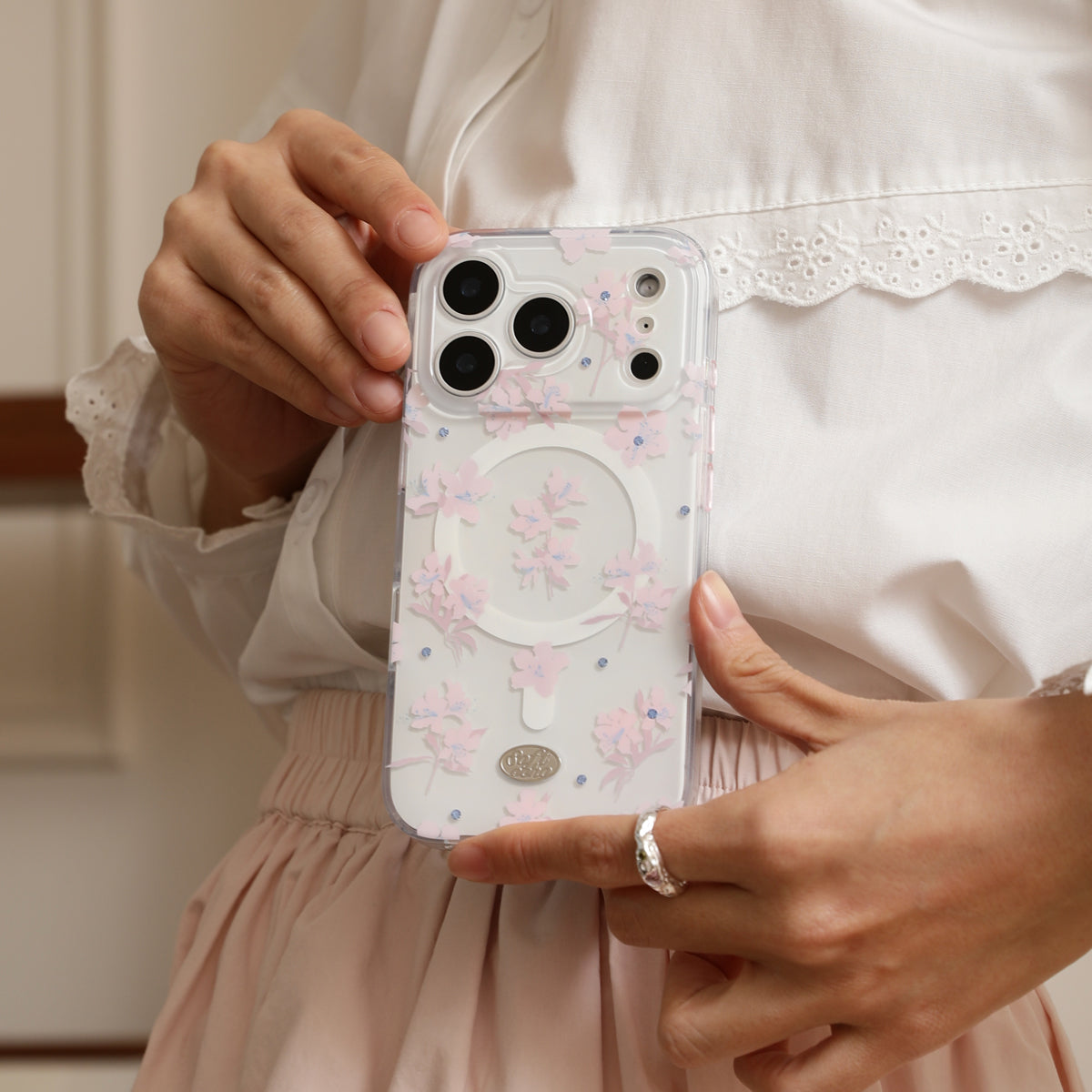 Person holding a phone with a floral case