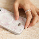 Hand with a ring on a phone case with floral design