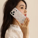 Woman holding a phone with a floral case against a beige background