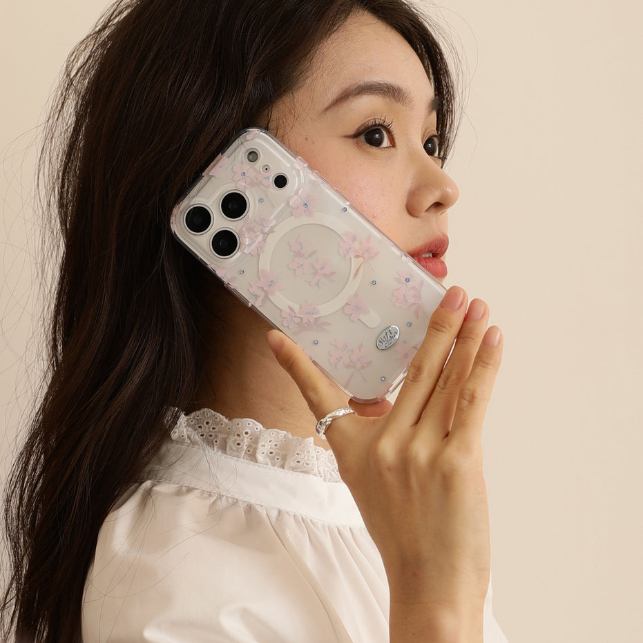 Woman holding a phone with a floral case against a beige background