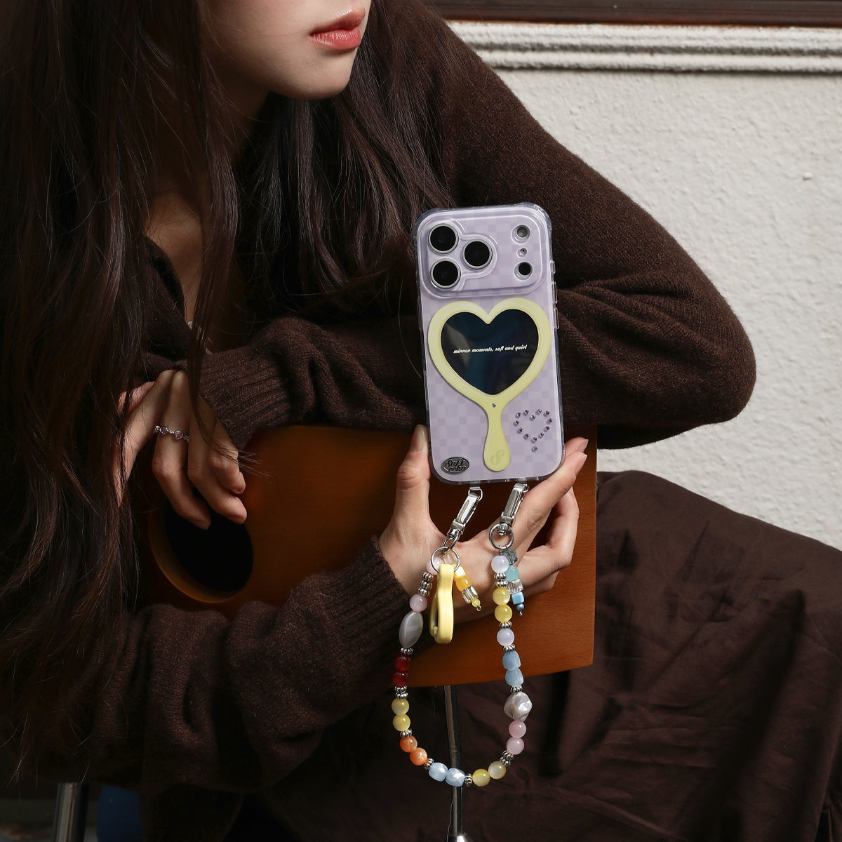 Person holding a phone with a heart design case